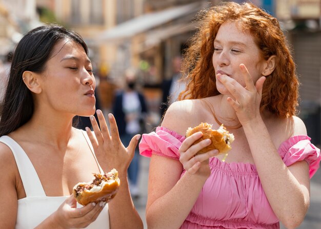 Best friends eating together some street food