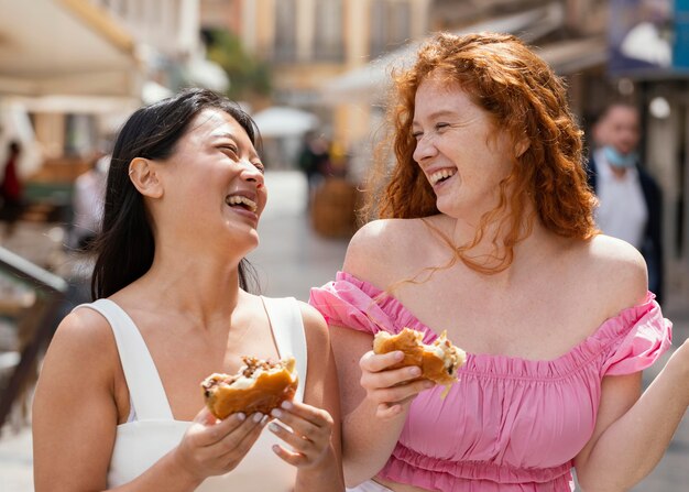 Best friends eating together some street food