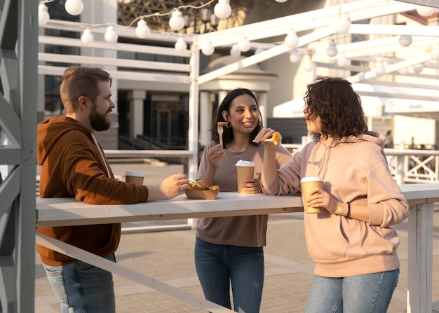 Foto gratuita migliori amiche che mangiano da strada all'aperto