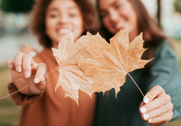 Free Photo best friends holding autumn leaves