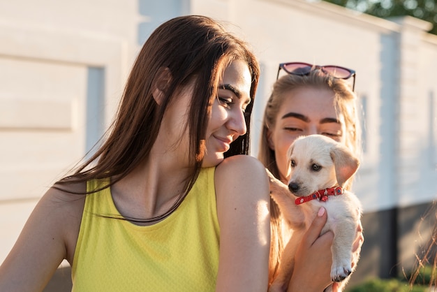 Best friends holding little dog