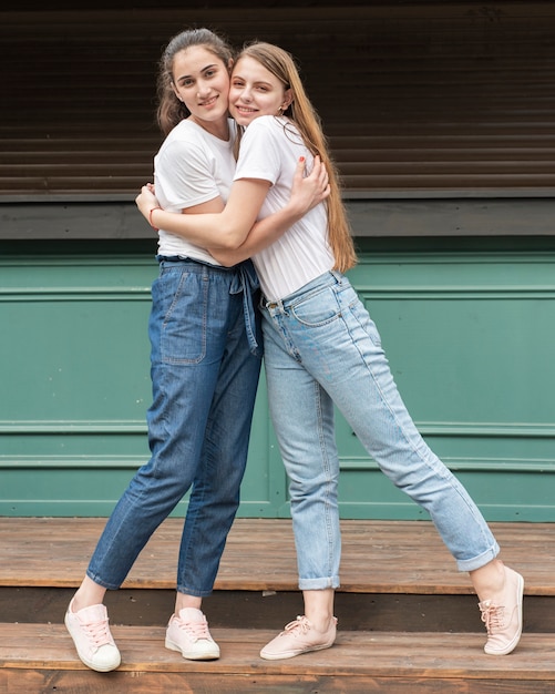 Best friends hugging and looking at the camera