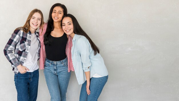 Best friends in jeans and shirts posing in studio