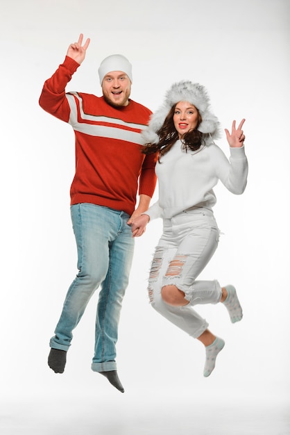 Best friends jumping together while wearing winter clothes