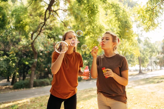 Best friends making soap bubbles together