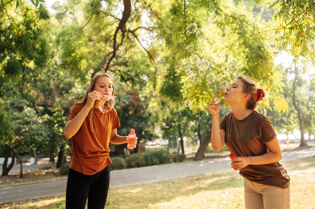 Best friends making soap bubbles