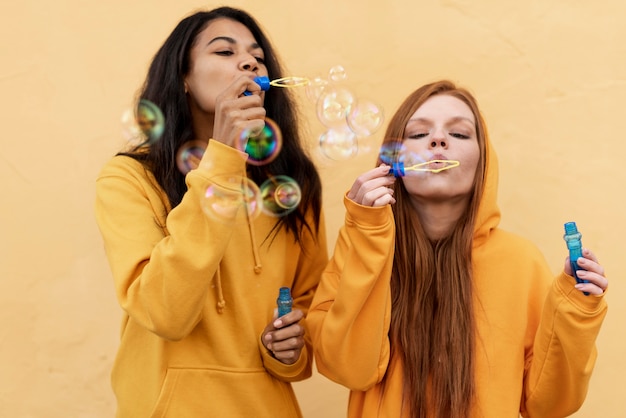 Best friends making soap bubbles