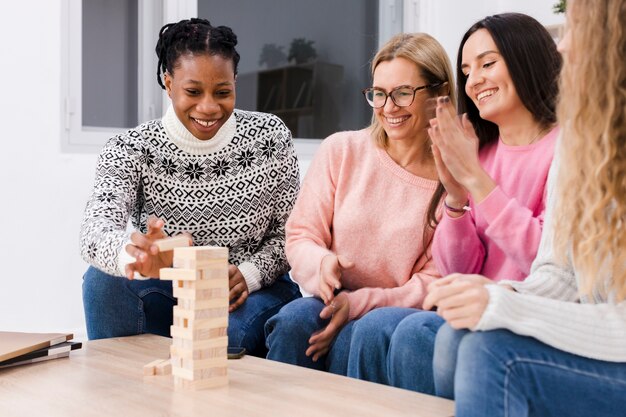 Best friends playing together a wooden tower game