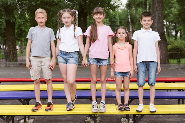 Free photo best friends posing on colorful bench