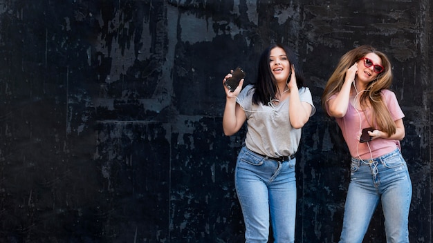 Best friends posing on a dark background with copy space