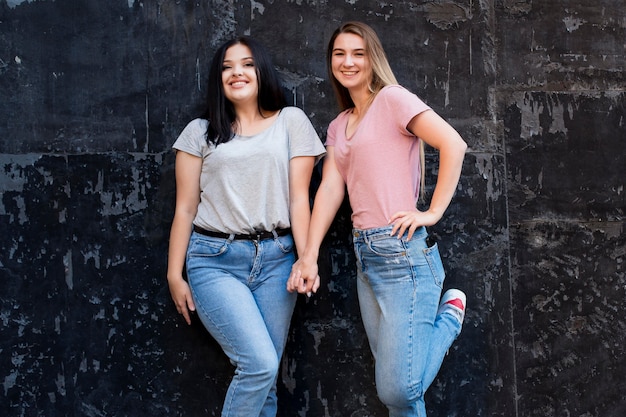 Free photo best friends posing on a dark background