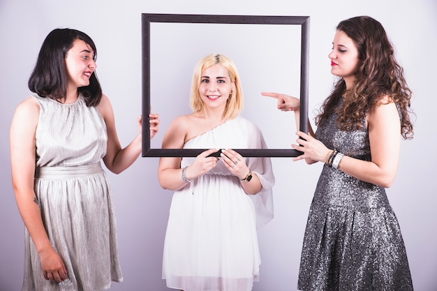 Best friends posing with a frame