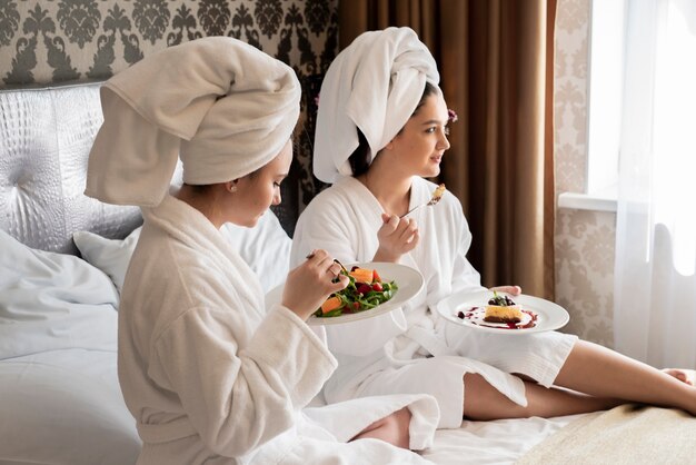 Best friends in robes eating some food