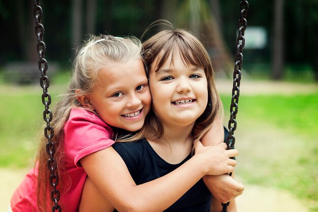 Best friends swinging in a park