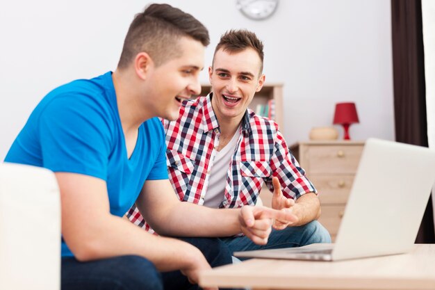 The best male friends spending time together with laptop