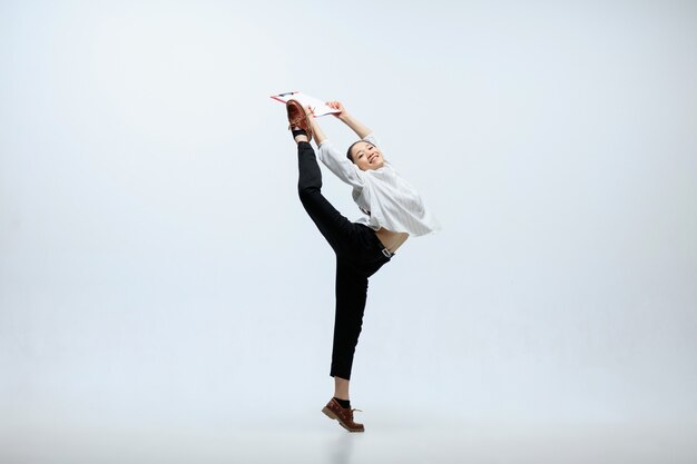 The best result can inspirate. Happy woman working at office, jumping and dancing in casual clothes or suit isolated on white studio background. Business, start-up, working open-space concept.