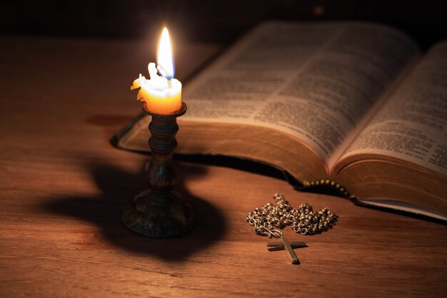 Библия, деревянный крест и свечи