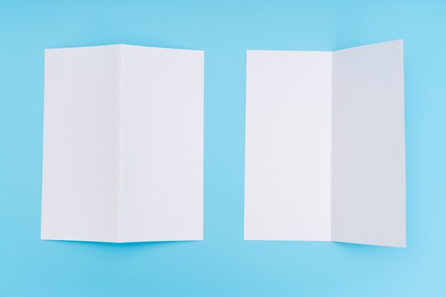 Bifold white template paper on blue background .