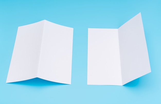 Bifold white template paper on blue background .