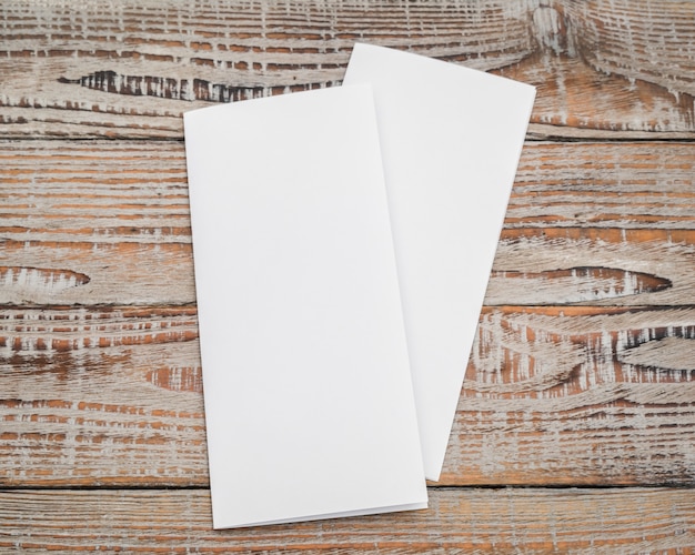 Двукратная белая бумага-шаблон на текстуре дерева.