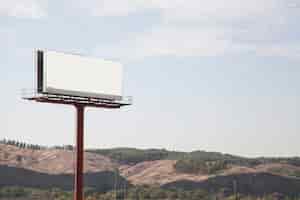 Бесплатное фото Большой рекламный щит с горами и небом на заднем плане