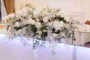 Foto gratuita il grande mazzo con le rose bianche e l'eucalyptus stanno su una tavola