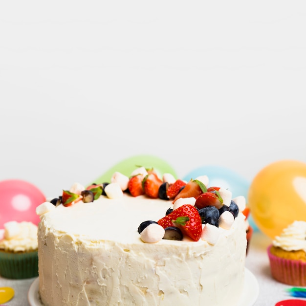 Big cake with different berries on table