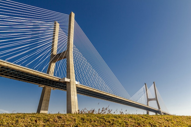 澄んだ青い空の下のフィールドに大きなセメント橋