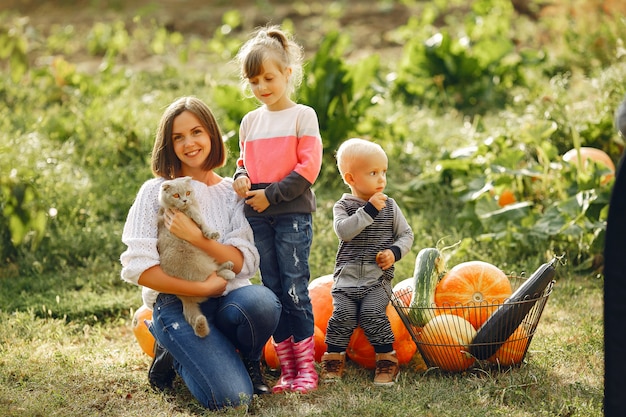 Big family sitting on a garden near many pumpkins