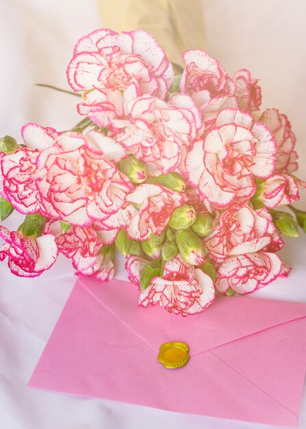 Big flowers bouquet with pink envelope on table