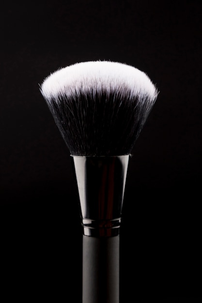 Big makeup brush on dark background