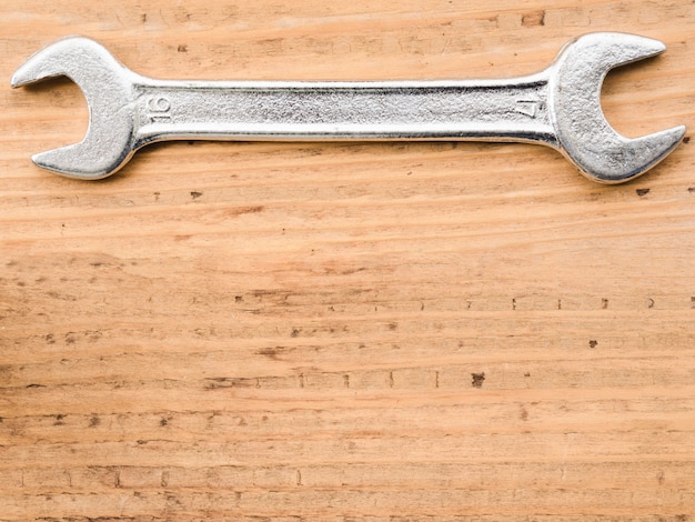 Большой металлический гаечный ключ на деревянный стол