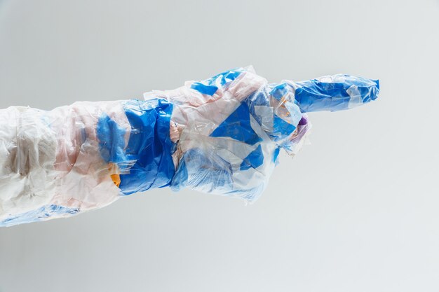 Big plastic hand made of garbage on white