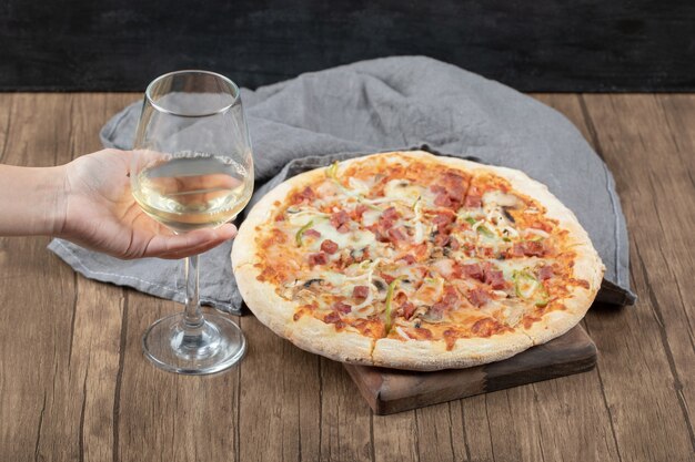 マルゲリータピザの大部分と白ワインのグラス