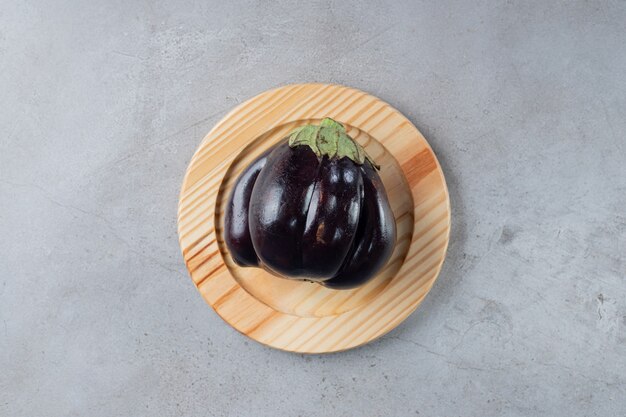 Большой фиолетовый овощ баклажана на деревянной доске. Фото высокого качества