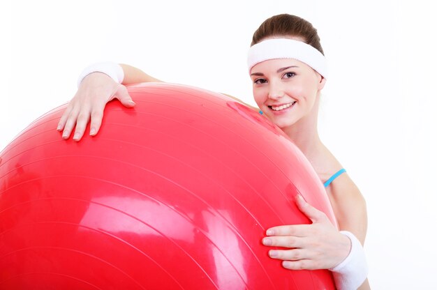큰 빨간 fitball 및 젊은 아름 다운 행복 한 여성 얼굴