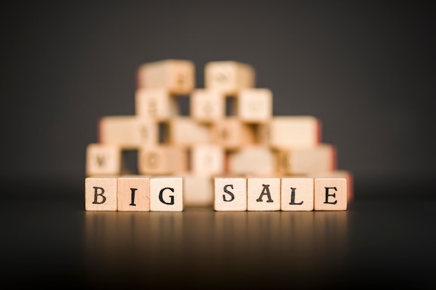 Free photo big sale inscription on wooden blocks on black table