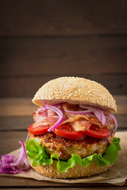 Big sandwich - hamburger burger with beef, red onion, tomato and fried bacon.