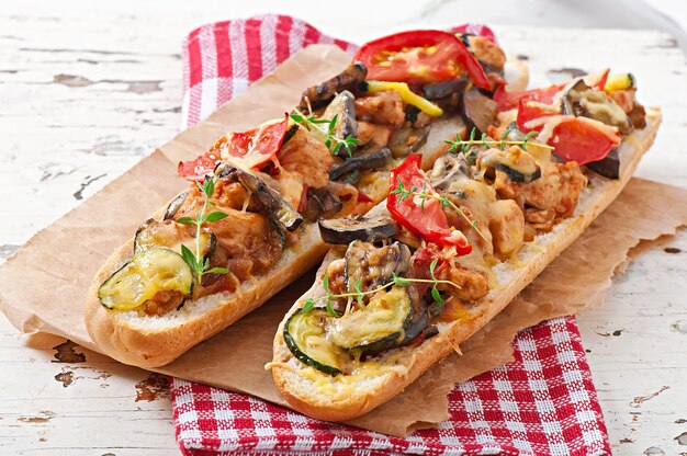 Big sandwich with roasted vegetables (zucchini, eggplant, tomatoes) with cheese and thyme
