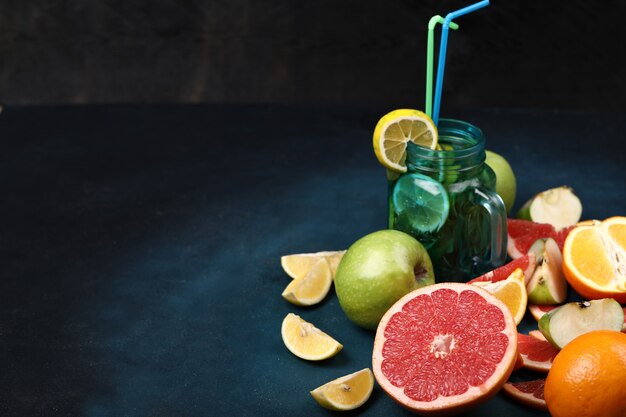 A big slice of grapefruit, slice fruits and a  jar of mojito.