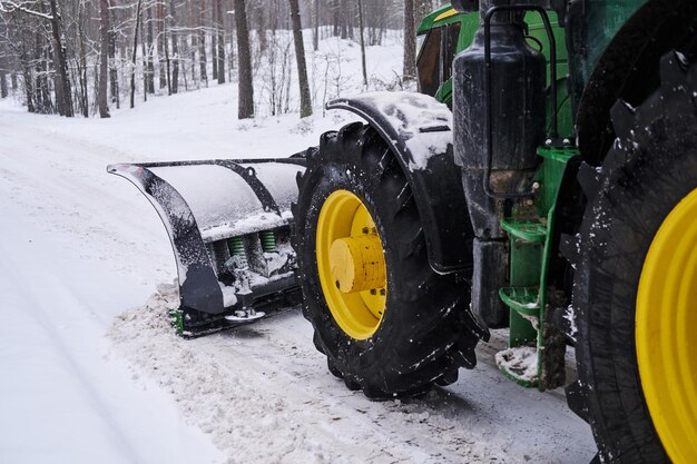 Big special tractor is removing snow from the forestal road.