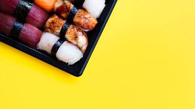 黄色の背景に大きな寿司黒プレート