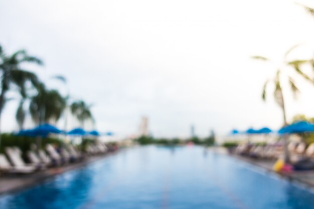 Big swimming pool with trees and deck chairs