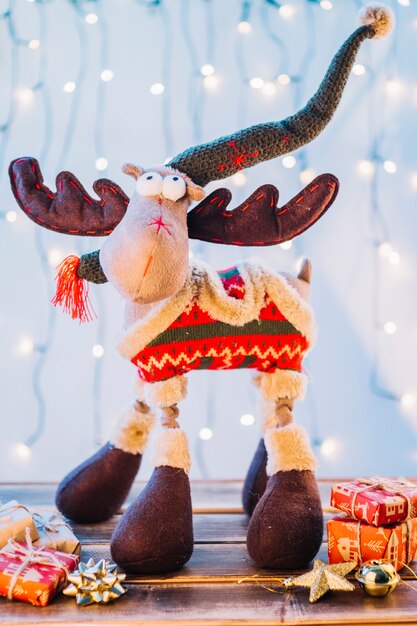 Big toy deer with gift boxes on table 