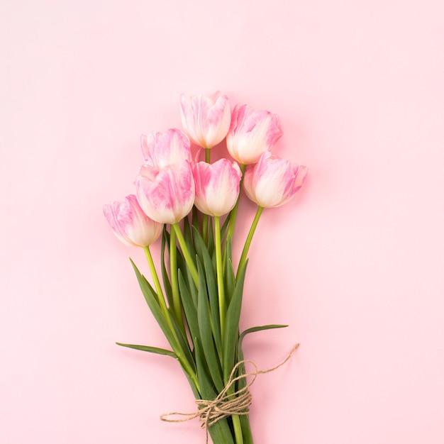 Большой букет тюльпанов на розовом столе