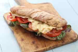 Free photo big vegan sandwich with vegetables on wooden board table