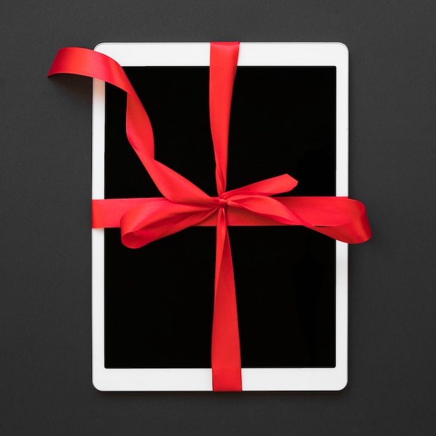 Big white tablet with red ribbon