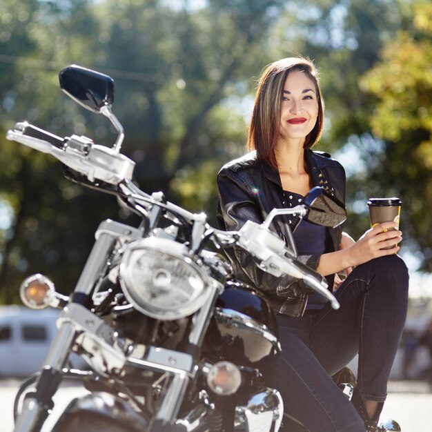 Biker girl in a leather jacket on a motorcycle