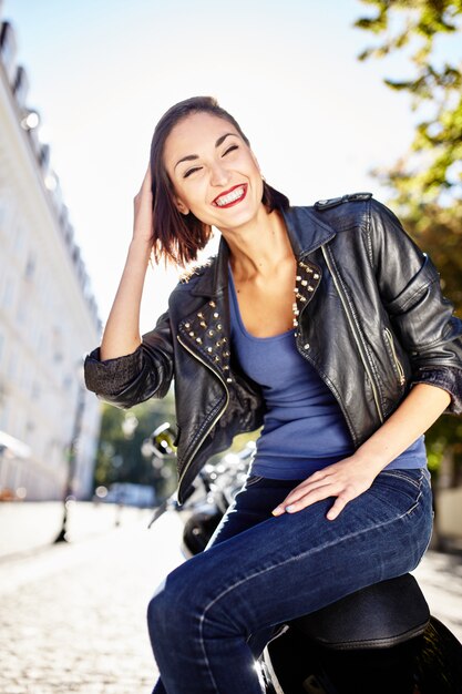 Biker girl in a leather jacket on a motorcycle