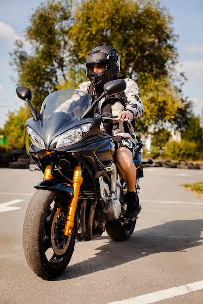 Free photo biker on the motorbike waiting to cross the road